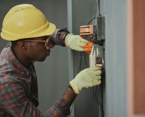 man in brown hat holding black and gray power tool