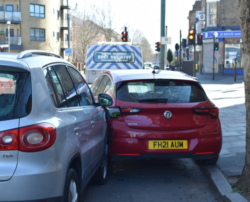 a red car is parked next to a silver car