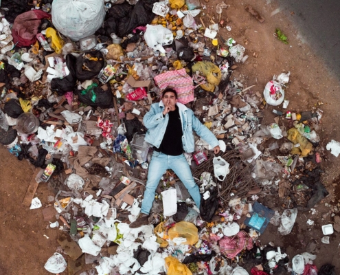 man lying on garbage pile in aerial photography