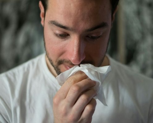 man wiping mouse with tissue paper