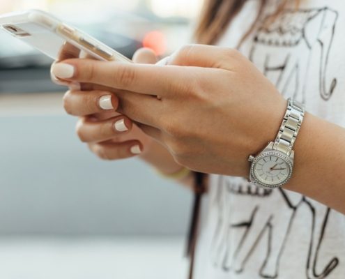 woman holding iPhone during daytime