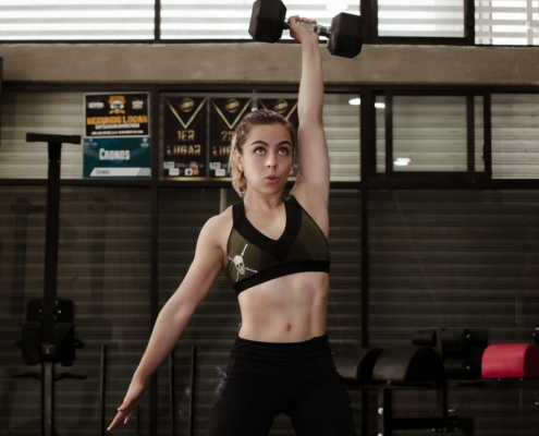 woman exercising with dumbbell inside gym